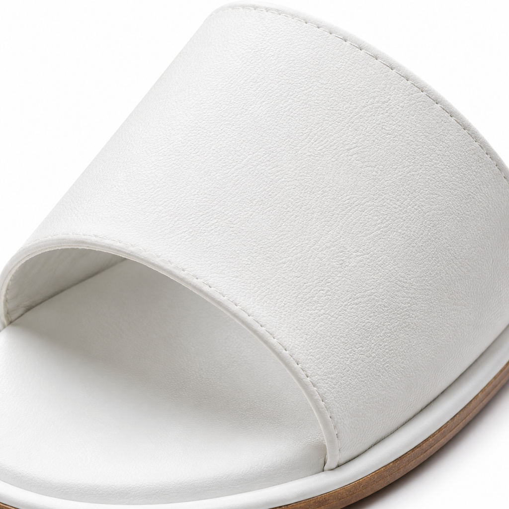 White leather slide sandals on a plain background.