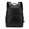 Front view of black crocodile-embossed leather backpack.