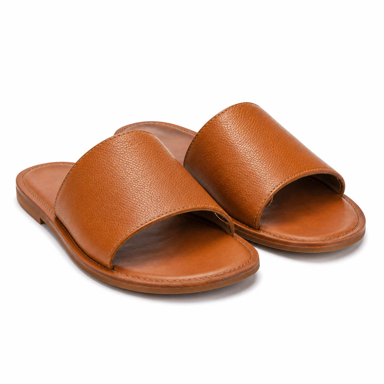 Side view of tan leather slip-on sandals with single strap